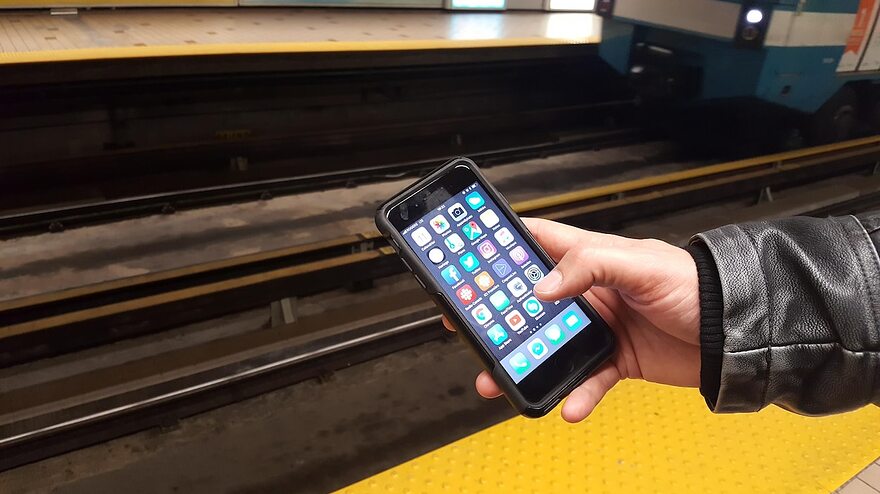 Un téléphone intelligent tenu par un utilisateur du métro