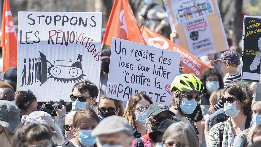 Des manifestants brandissent des pancartes sur lesquelles on peut lire : « un registre des loyers pour lutter contre la pauvreté » ou encore « stoppons les rénovictions ».