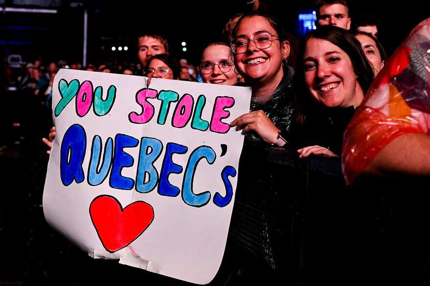 Plusieurs affiches s'élevaient devant Benson Boone, dans la foule.