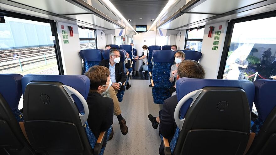 Des gens sont assis à l'intérieur d'un train entièrement alimenté à l'hydrogène.