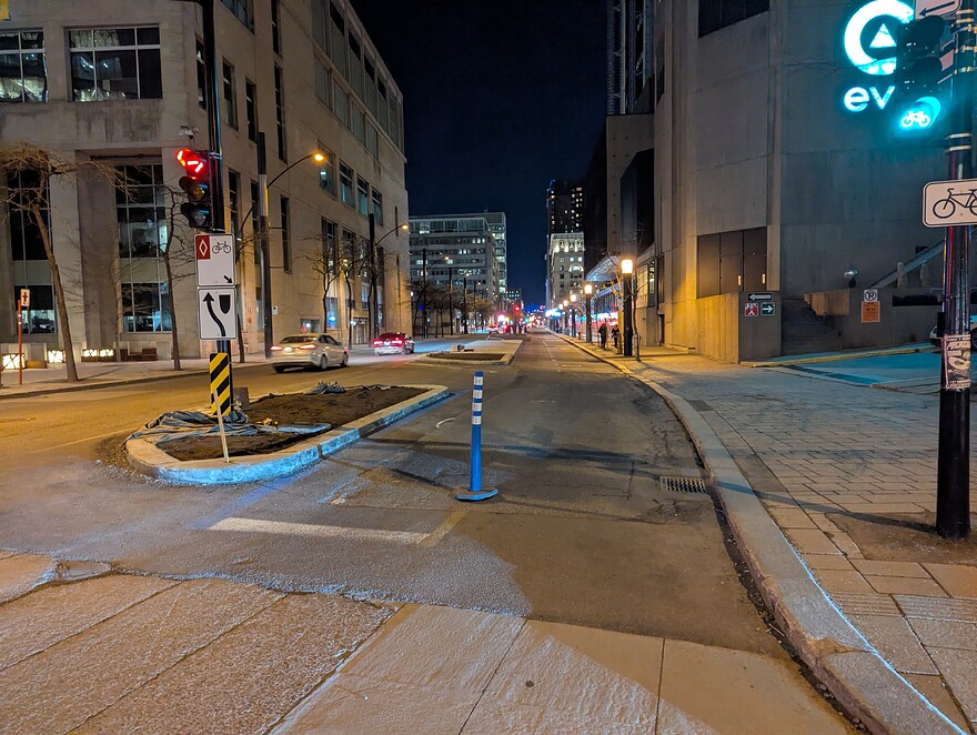 Saint-Antoine / Robert-Bourassa, vue vers l'est, avec un flexpost placé sur la ligne axiale de la piste cyclable.