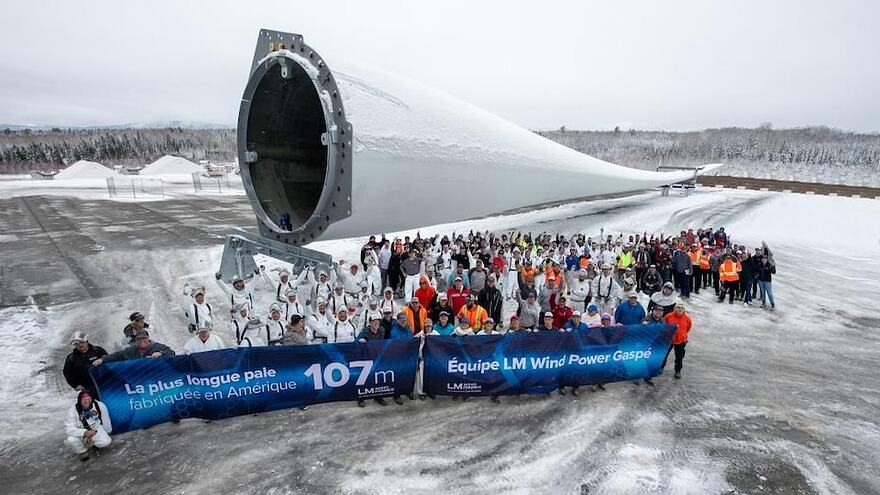 L'équipe de l'usine LM Wind Power de Gaspé pose fièrement devant la première pale d'éolienne géante de 107 mètres.