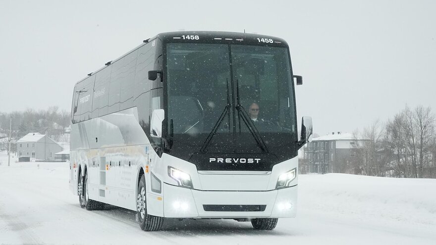 Un autocar sur la route en pleine tempête de neige.