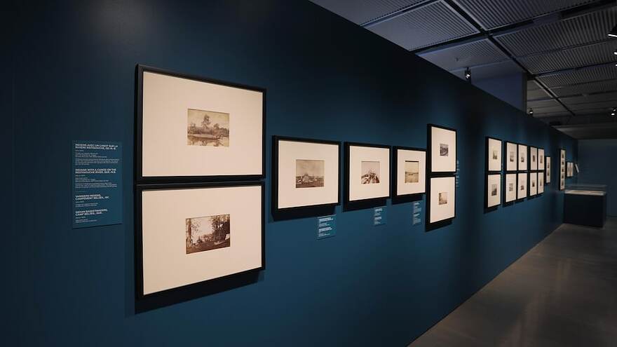Des photos encadrées sont exposées dans un musée.