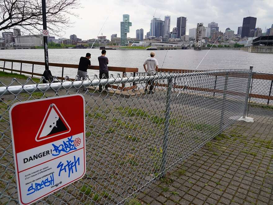 people fishing behind fence