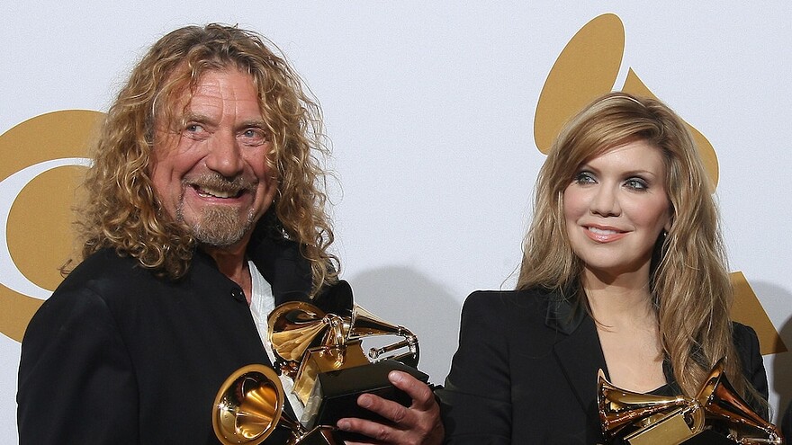 L'homme et la femmes tiennent leurs trophées sur le tapis rouge des Grammy.