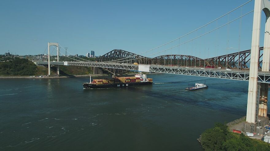 Un bateau passe sur le fleuve sous le pont Pierre-Laporte.