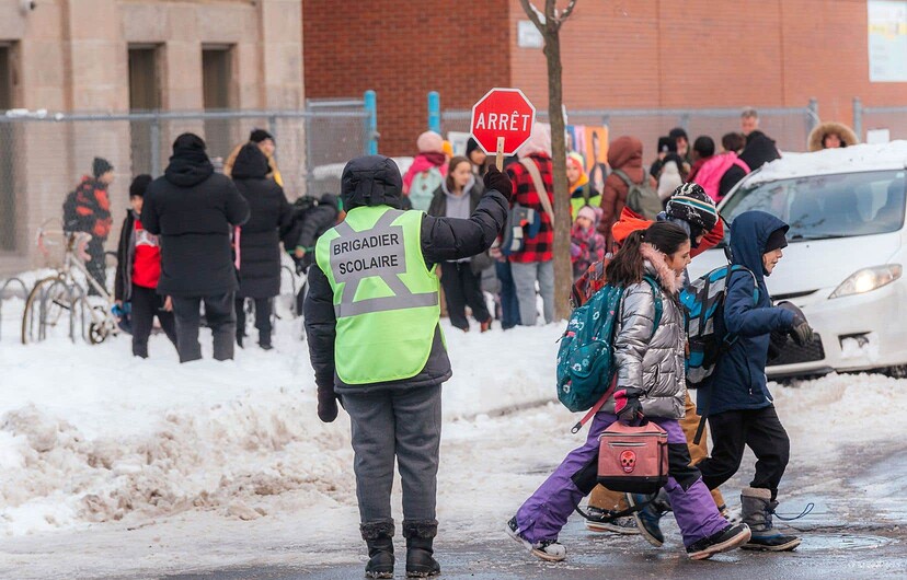 Une brigadière scolaire au travail à la sortie de l'école primaire Saint-Clément dans Maisonneuve, à Montréal.