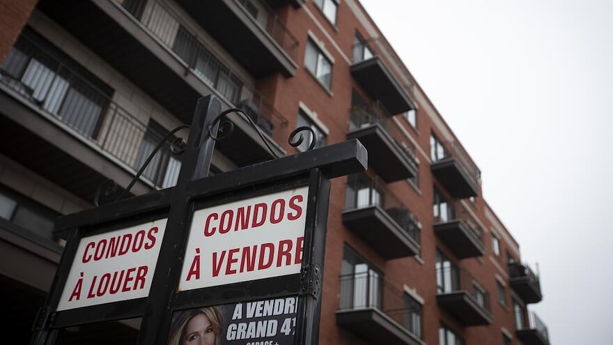Pancarte indiquant des condos à vendre et à louer devant un immeuble d'habitation.