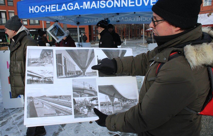 Une affiche à la main montrant des images des structures aériennes de la première phase du REM, dans l’ouest de l’île de Montréal, Maxime Geraldes se dit « inquiet » par ce projet de transport.