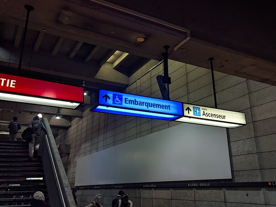 Backlit métro signage indicating where wheelchair users should board.