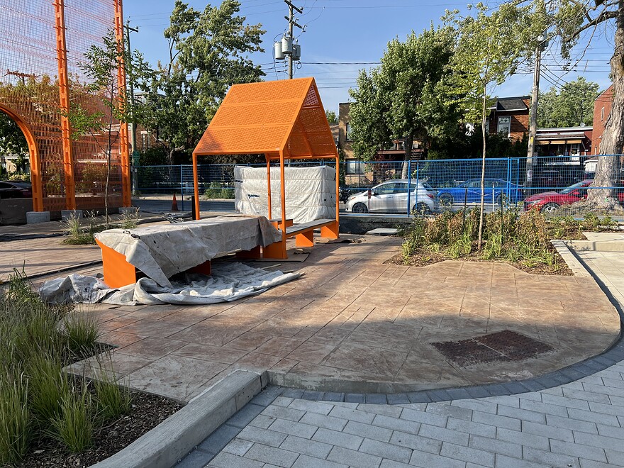 Orange metal sitting area with pitched roof covering