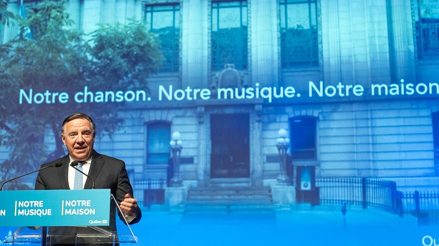 François Legault devant une image annonçant que la Bibliothèque Saint-Sulpice deviendra la Maison de la chanson et de la musique du Québec