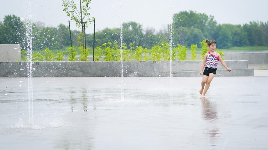 Une fillette profite des jeux d'eau de la plage de l'Est de Montréal.