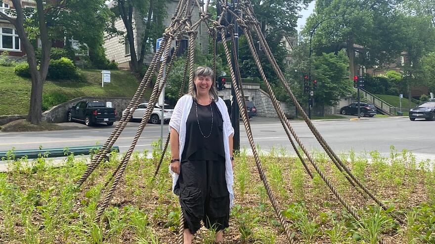 Une femme devant une sculpture au coin d'une rue à Montréal.