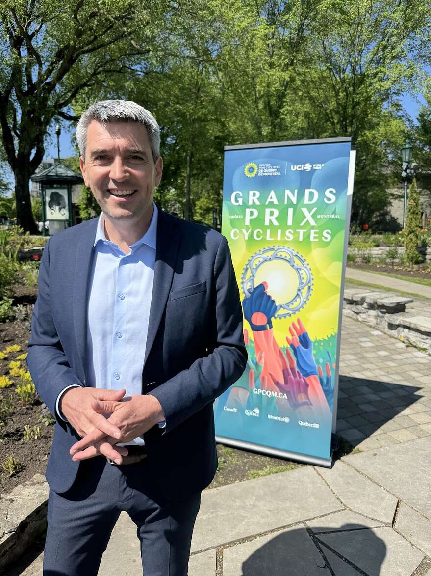 Joseph Limare pose avec le nouveau logo du Grand Prix cycliste de Québec.