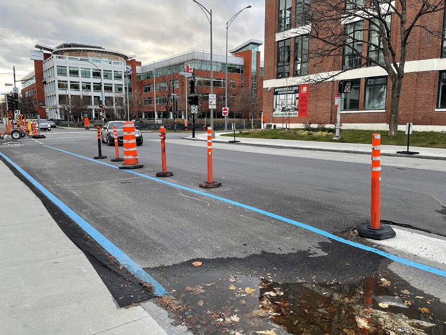 Couche d'asphalte encore présente sur la piste et sur le mail de béton qui permet un plus grand rayon de braquage pour les véhicules en provenance de la sortie d'autoroute