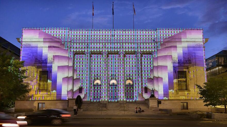 Une oeuvre numérique est projetée sur une façade du Musée des beaux-arts de Montréal.