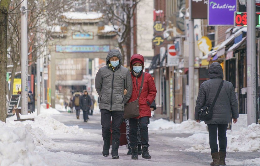 Un couple marche dans le Quartier chinois à Montréal en hiver.