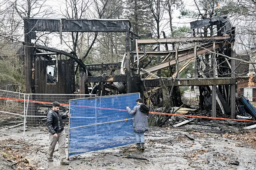 PHOTO GRAHAM HUGHES, LA PRESSE CANADIENNE / Des travailleurs installent des clôtures de sécurité autour de la maison de l’artiste Charles Daudelin, qui a été détruite à la suite d’un incendie, le 30 décembre 2024.