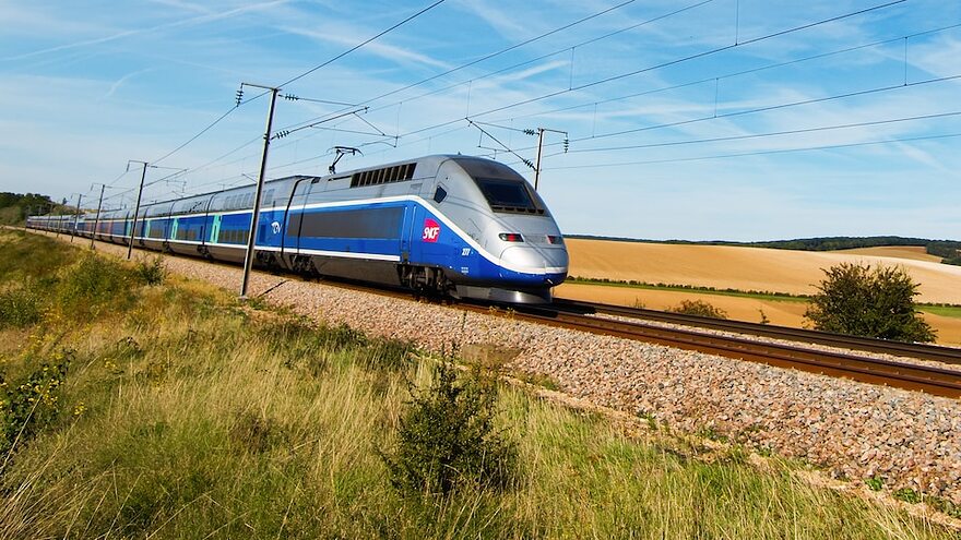 Un train à grande vitesse traverse des champs en France.