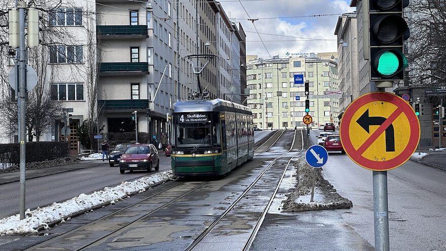 Une voie réservée pour le tramway au milieu avec des voitures chaque côté.