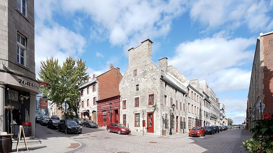 Croisement de deux rues dans le Vieux-Montréal montrant des bâtiments patrimoniaux.