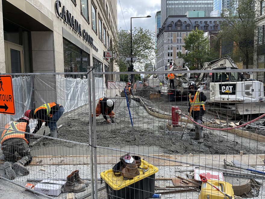 Coulage du béton pour le trottoir au coin sud-est de l'intersection entre Peel et Sainte-Catherine