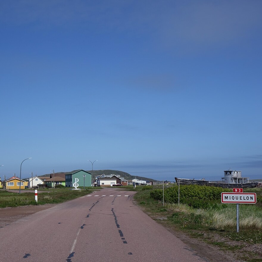 Une route menant à Miquelon avec des maisons au loin.