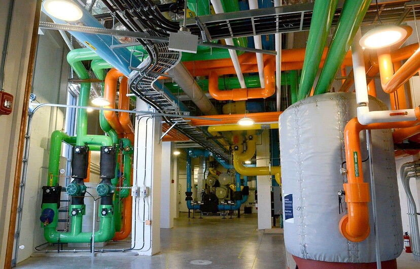 Aux étages inférieurs d’une des tours d’appartement de Zibi se trouve la salle mécanique, où de multiples tuyaux colorés transportent l’eau chaude provenant de l’usine Kruger, qui permet d’alimenter en chaleur le bâtiment.