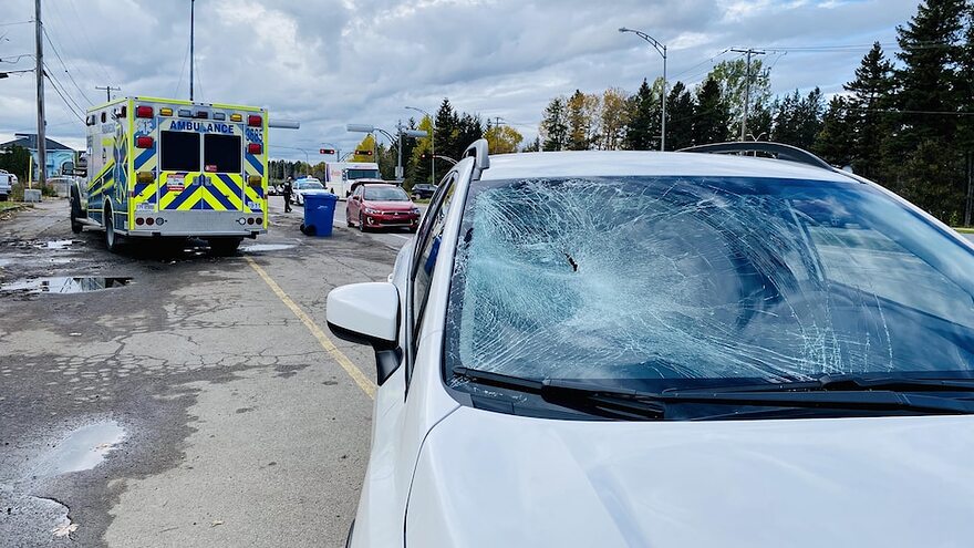 Un véhicule avec le pare-brise éclaté est placé devant une ambulance.