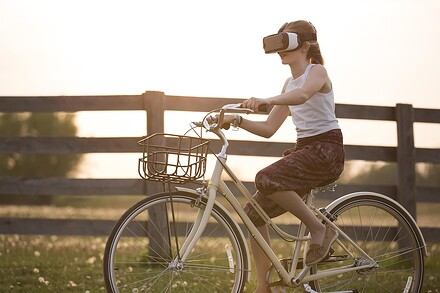 Femme en vélo avec un casque de réalité virtuelle sur la tête