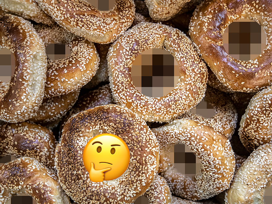 A photo of a pile of bagels with their holes blurred