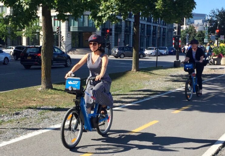 Valérie Plante circule sur un vélo électrique de Bixi sur une piste cyclable.