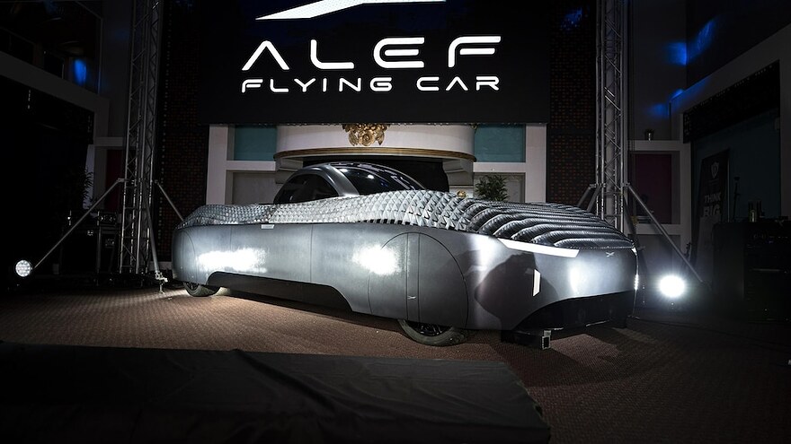 Une voiture sport grise avec un design futuriste dans un salon automobile.