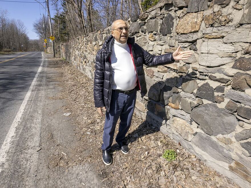 Bachir Azzi shows the stone wall on the north side of Gouin Blvd. in the Bois-de-Saraguay Nature Park. The wall cannot be moved to expand the roadway to add a second sidewalk.