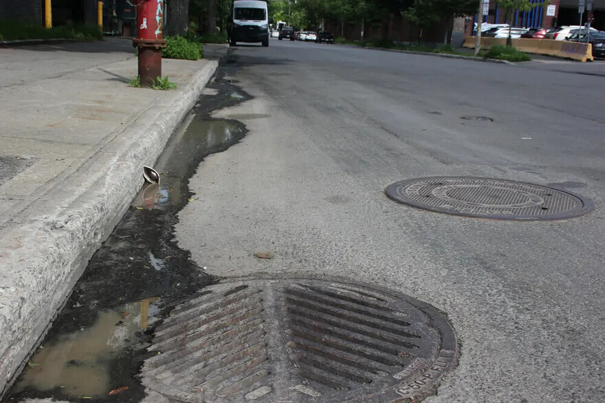 Des traces d'écoulements sont visibles sur le trottoir et dans la rue.