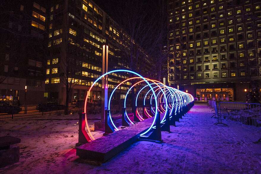 Cette installation est constituée de 20 cercles lumineux qui forment un tunnel que les passants peuvent traverser ainsi qu'un système sonore. Sur la photo, lors du festival Montréal en lumière.