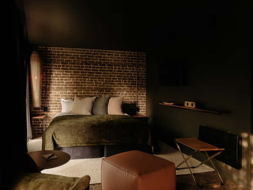 Rooms that could otherwise feel dark and closed in are instead warm and cozy, thanks in part to good lighting and two large arched windows facing the street. —MATDEROME/Supplied