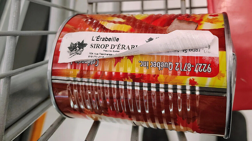 Conserve de sirop d’érable de L’Érabeille vendue chez Adonis, dont l’étiquette recouvre la mention de la compagnie à numéro de Steve Bourdeau. — Photo : Courtoisie