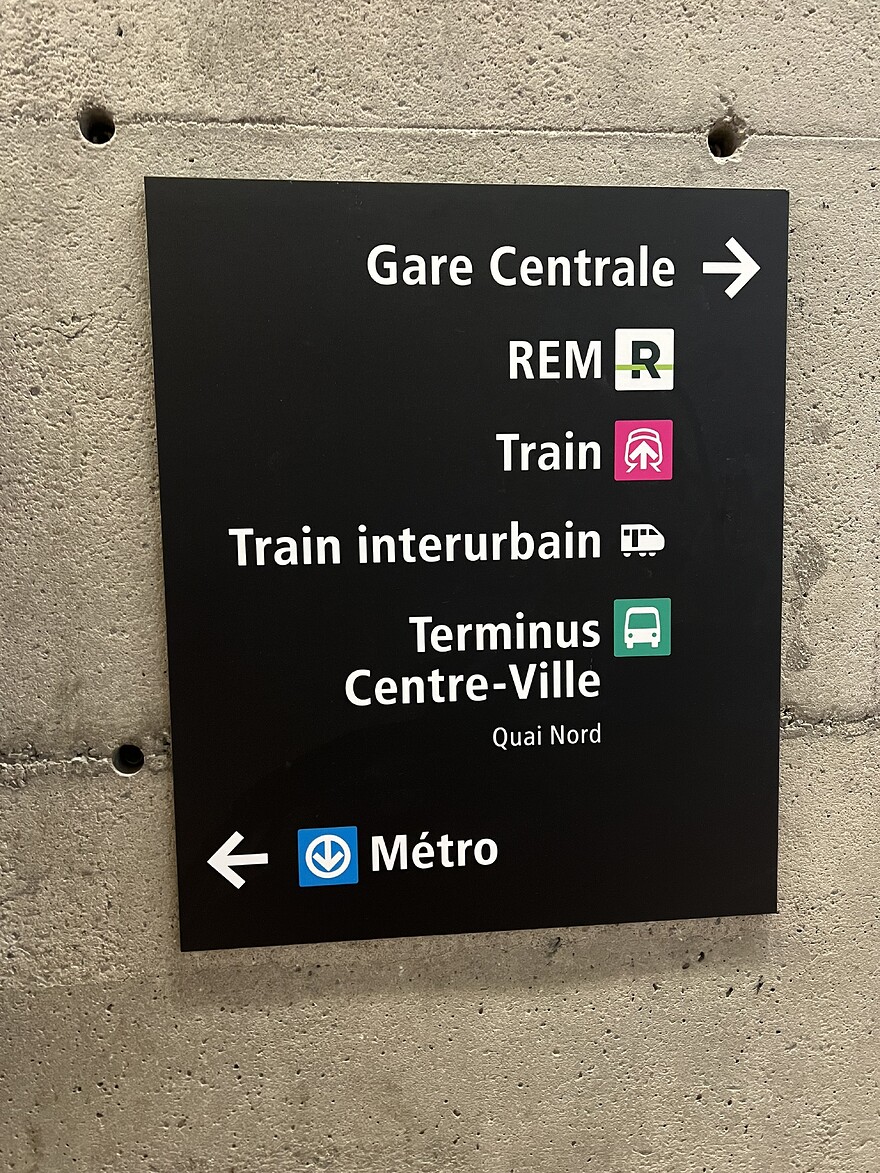 Sign under Le 1000 pointing to the REM, Train, Train interurban, and Terminus Centre-Ville, with Quai Nord as the subheading.