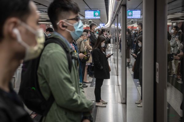 Passengerswait for a subway trainin Hong Kong.