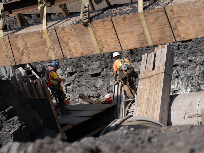 Deux travailleurs en action sur un chantier de construction.