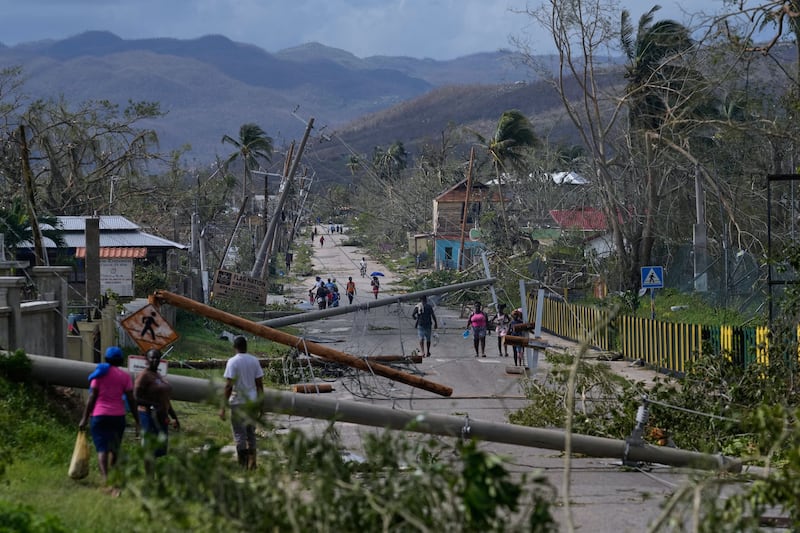 Des habitants traversent Lacovia Tombstone, en Jamaïque, au lendemain de l'ouragan <i>Melissa</i>, mercredi 29 octobre 2025.|800x533.3869670152856