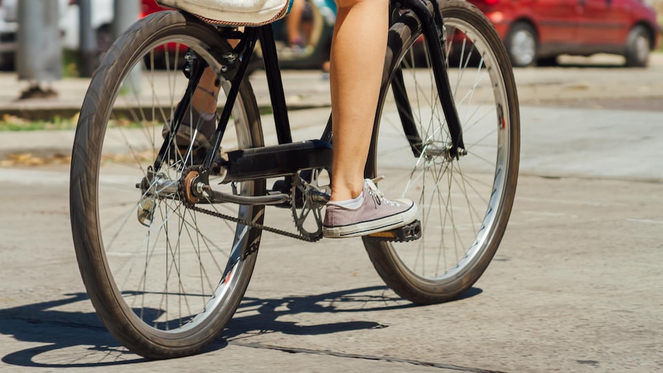 Gros plan sur les jambes d'une personne sur un vélo.
