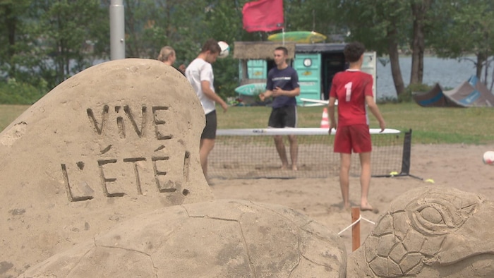 Une tortue en sable sur laquelle il est inscrit : « vive l'été ».