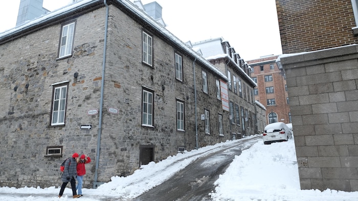 Deux personnes marchent à côté du bâtiment au coin des rues Dauphine et Sainte-Angèle.