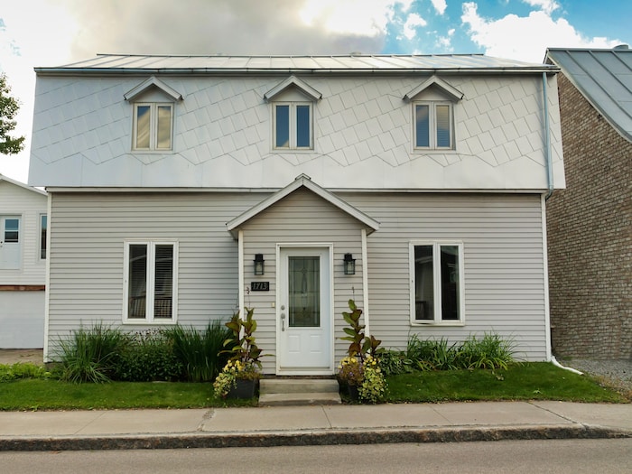 Une maison de style ouvrier, avec un toit et un recouvrement gris, à Sillery.