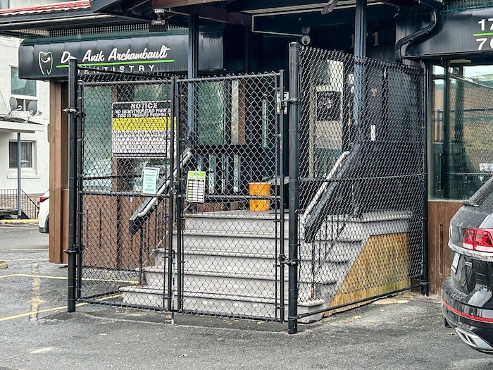 Une clôture ceinture les escaliers d'un cabinet de dentiste situé au centre-ville du Grand Sudbury.