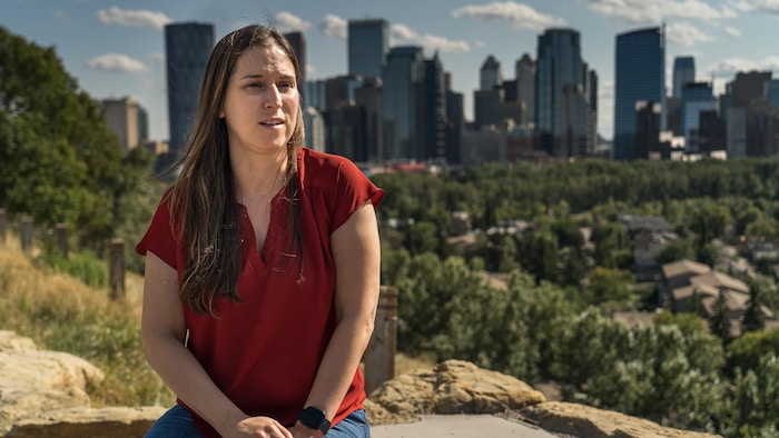 Une femme pose avec la ville de Calgary en arrière-plan.